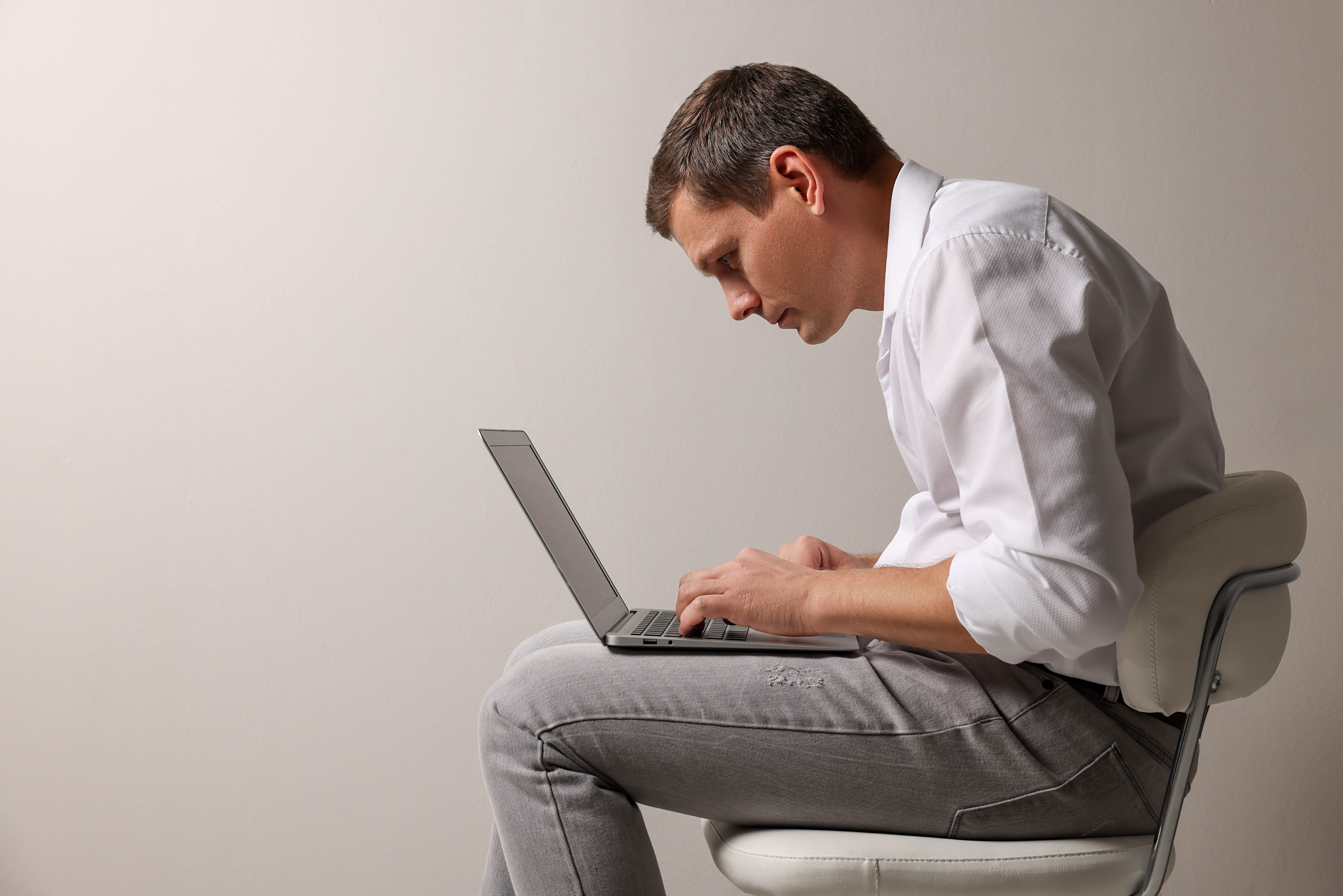 Man hunched over his laptop, demonstrating horrible posture Man hunched over his laptop, demonstrating horrible posture